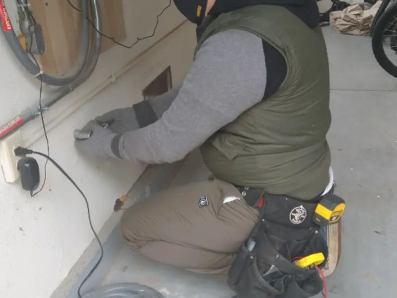 Electrician performing outlet wiring in a Watford City garage